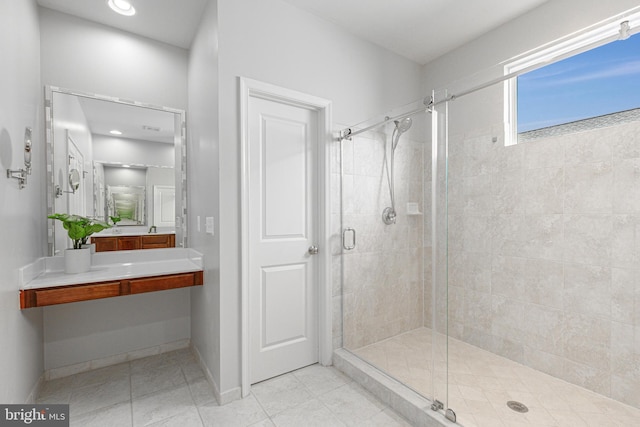 full bathroom with a stall shower, vanity, baseboards, and tile patterned floors