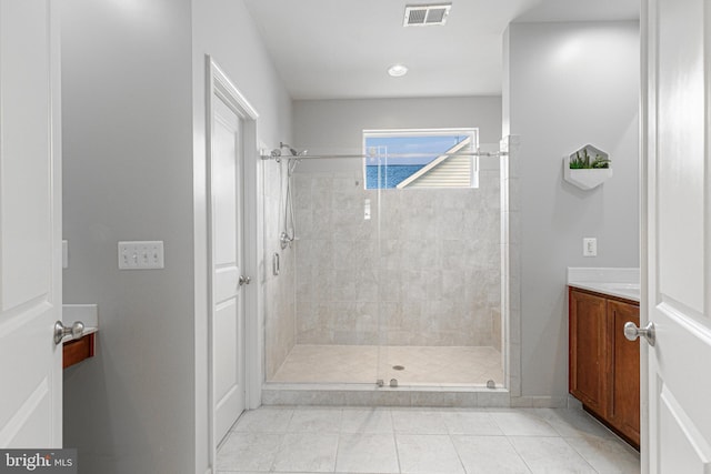 full bathroom featuring a stall shower, tile patterned flooring, visible vents, and vanity