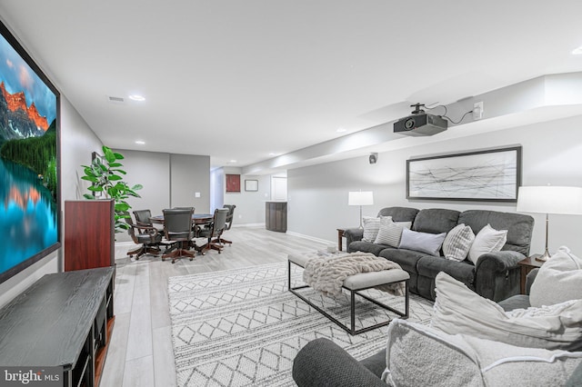 living area featuring baseboards, wood finished floors, and recessed lighting