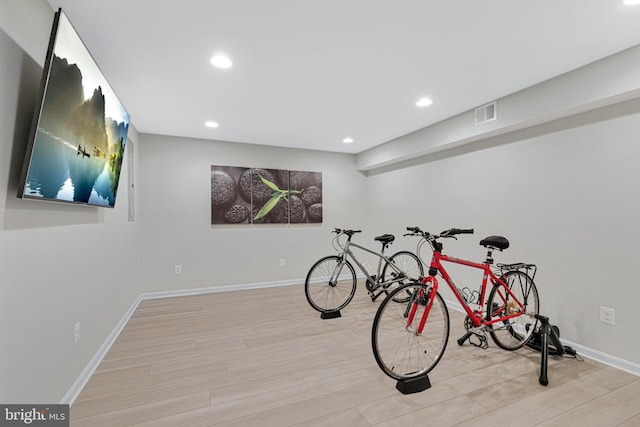 exercise room featuring visible vents, baseboards, wood finished floors, and recessed lighting