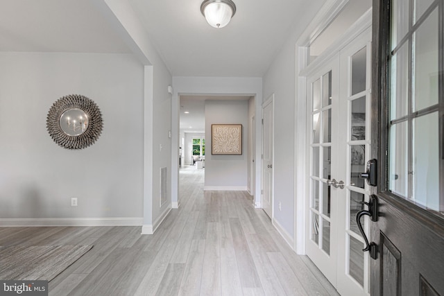 corridor with french doors, baseboards, and wood finished floors