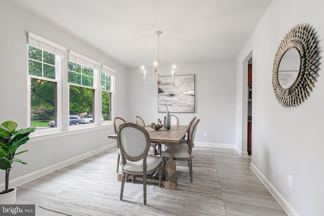 dining room with an inviting chandelier, baseboards, and wood finished floors