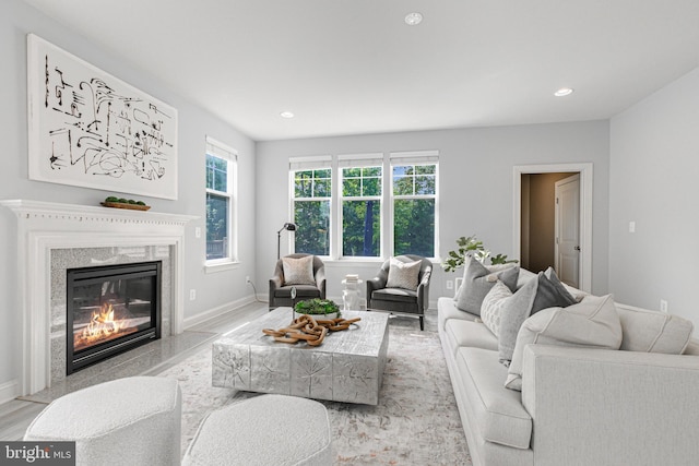 living area with recessed lighting, a fireplace, wood finished floors, and baseboards