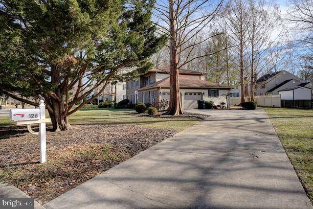 view of front of home with driveway, a garage, fence, and a front yard