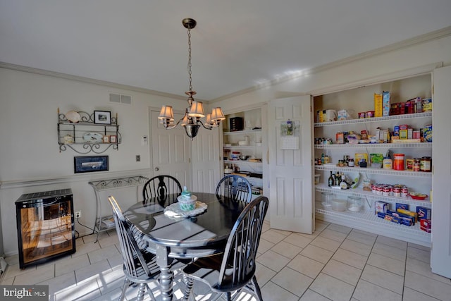 dining area with built in features, light tile patterned floors, visible vents, and crown molding