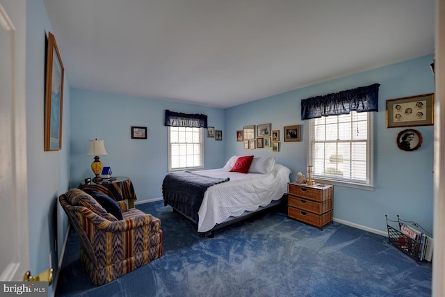 bedroom featuring multiple windows, dark carpet, and baseboards