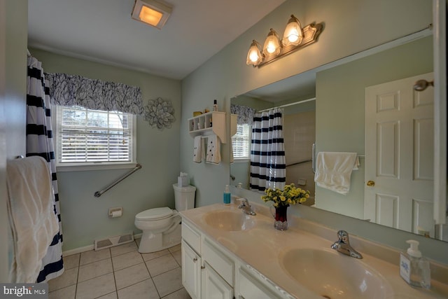 bathroom with double vanity, a sink, visible vents, and tile patterned floors