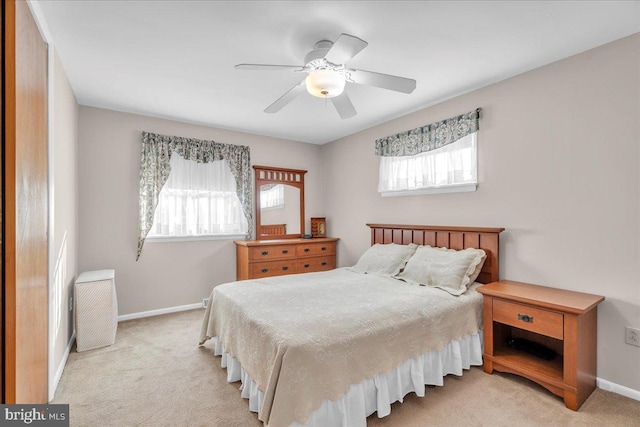 bedroom featuring baseboards, a ceiling fan, and light colored carpet