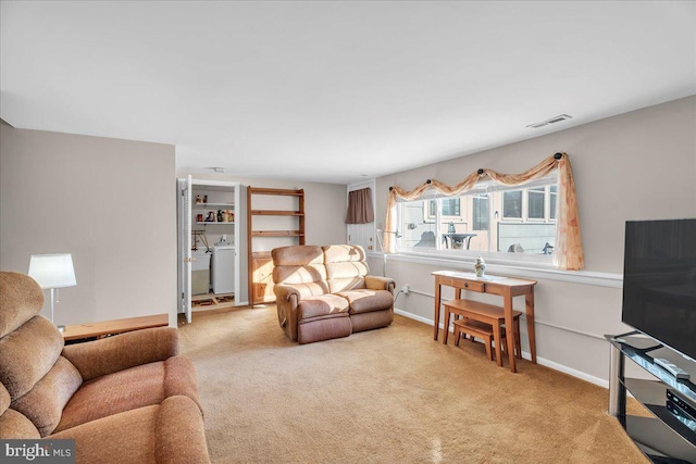 living area with carpet, visible vents, washer / clothes dryer, and baseboards