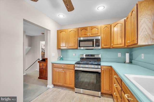 kitchen featuring recessed lighting, light countertops, appliances with stainless steel finishes, a sink, and ceiling fan