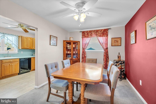 dining room featuring light carpet, ceiling fan, and baseboards