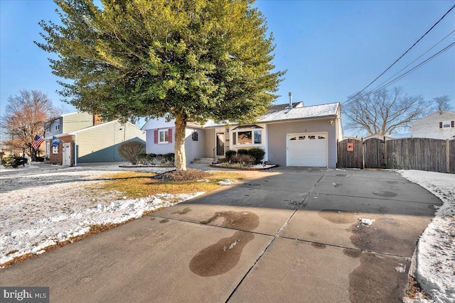 ranch-style home featuring concrete driveway, fence, an attached garage, and a gate