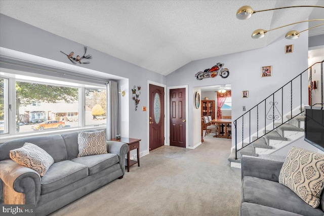 living area with baseboards, light colored carpet, lofted ceiling, stairway, and a textured ceiling