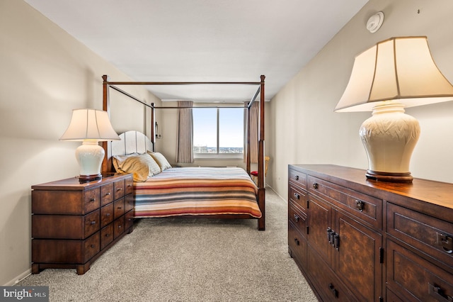 bedroom featuring light carpet and baseboards