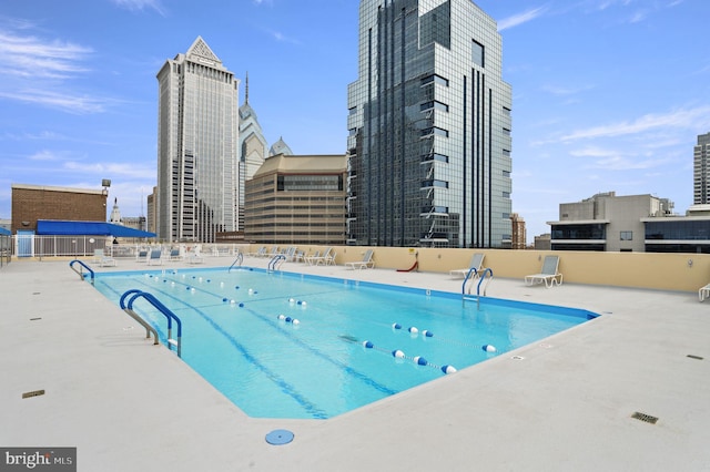 pool with a view of city and a patio area