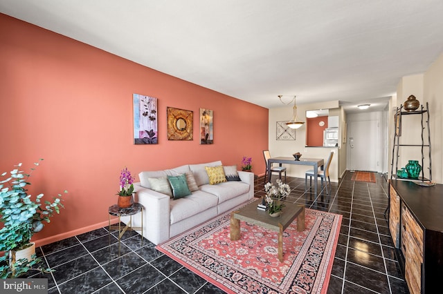 living area with dark tile patterned flooring and baseboards