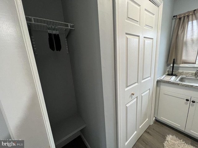 laundry area with a sink and dark wood-type flooring