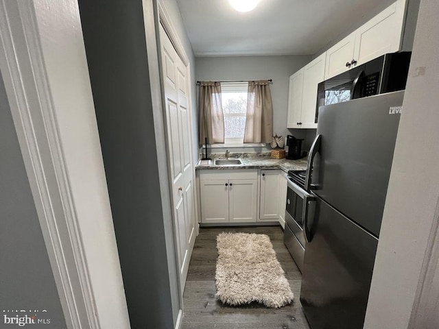 kitchen featuring white cabinets, dark wood-style floors, stainless steel appliances, and a sink