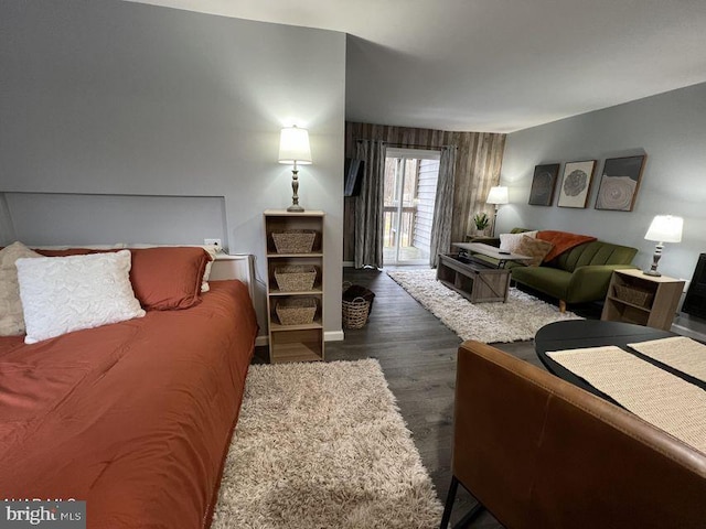 bedroom with dark wood-style floors and access to exterior