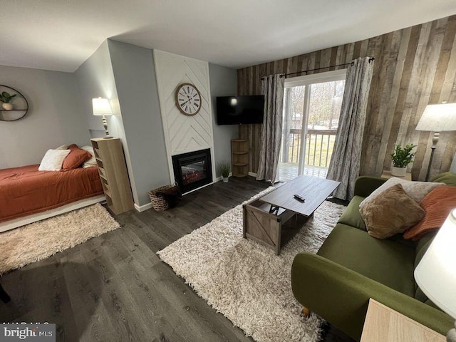 living area featuring a large fireplace and dark wood finished floors