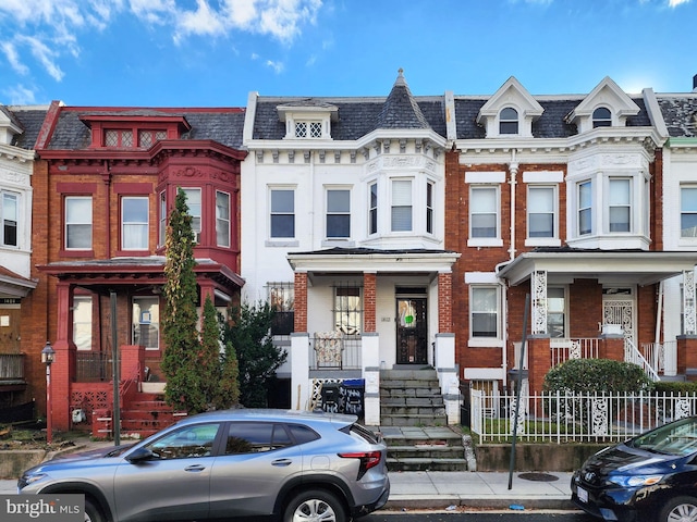 multi unit property featuring a high end roof, brick siding, and mansard roof