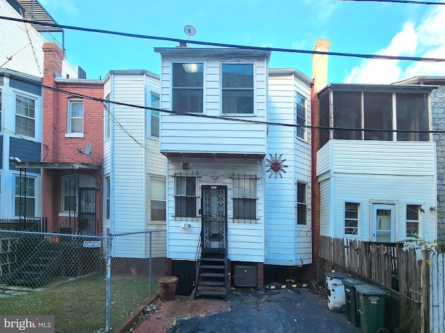 view of property with fence private yard, a sunroom, and entry steps