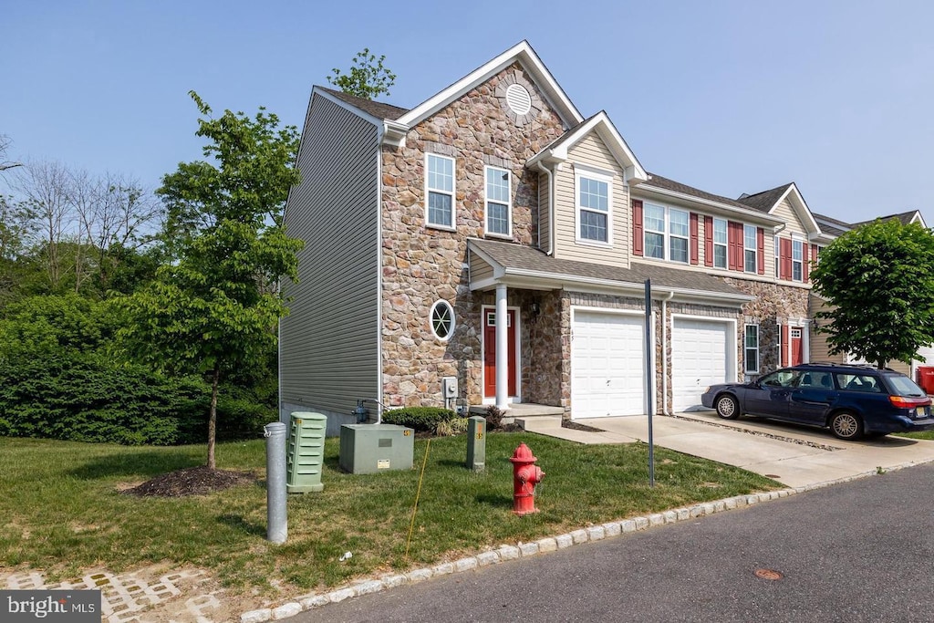 view of front of home featuring a front lawn, stone siding, driveway, and an attached garage