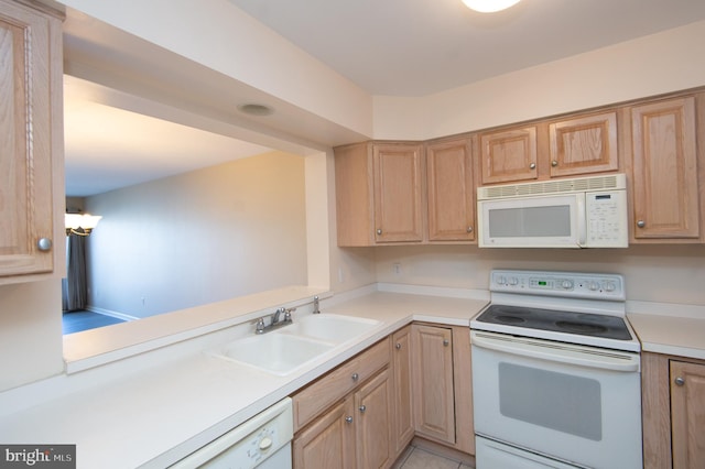 kitchen featuring white appliances, light brown cabinets, light countertops, and a sink