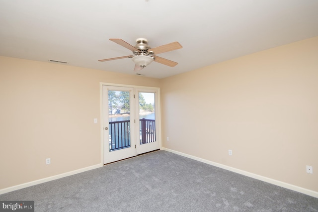 carpeted spare room featuring a ceiling fan and baseboards