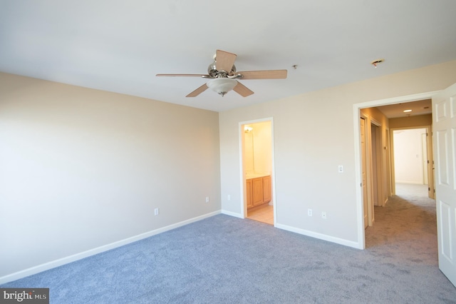 unfurnished bedroom featuring ensuite bathroom, ceiling fan, light colored carpet, and baseboards