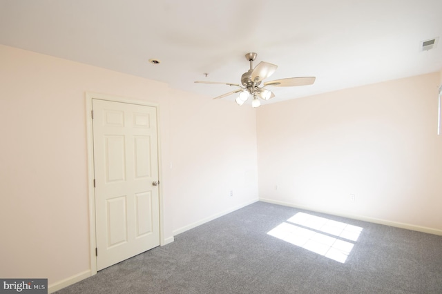 carpeted empty room with visible vents, ceiling fan, and baseboards