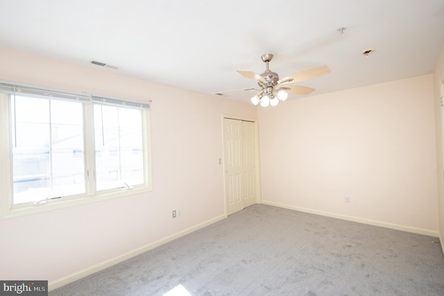 unfurnished room with visible vents, baseboards, ceiling fan, and carpet flooring