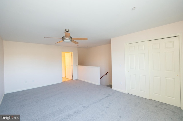 unfurnished bedroom with carpet floors, ceiling fan, baseboards, and a closet