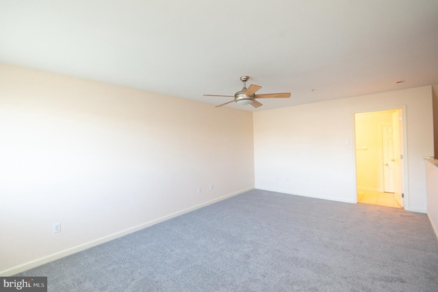 spare room with ceiling fan, carpet floors, and baseboards