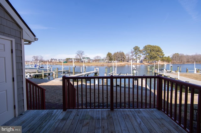 wooden deck featuring a water view, a boat dock, and boat lift