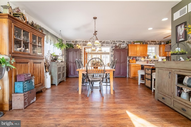 dining space featuring an inviting chandelier, wallpapered walls, wood finished floors, and recessed lighting