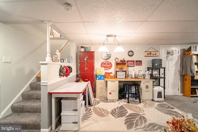 interior space with baseboards, a drop ceiling, and carpet flooring