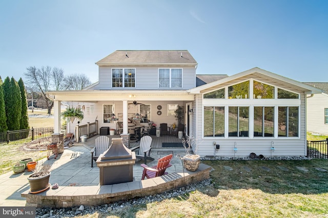 back of property with a yard, an outdoor fire pit, a patio area, and fence