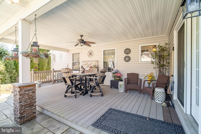 wooden deck featuring outdoor dining area and a ceiling fan