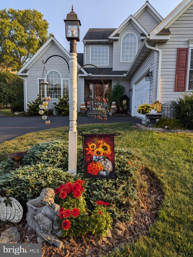 view of front of property featuring driveway and a front lawn