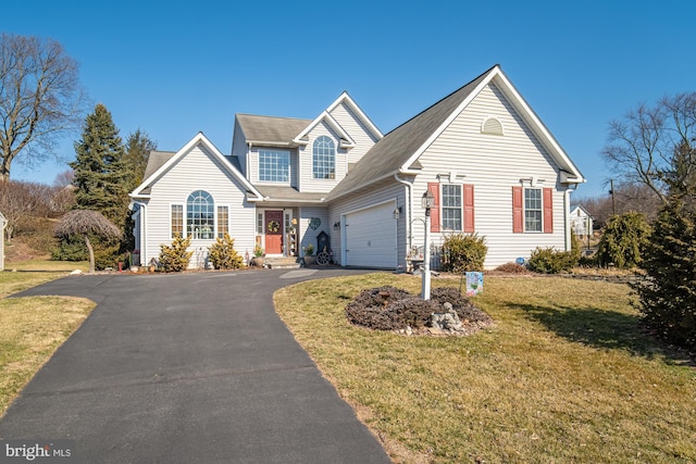 view of front of property featuring aphalt driveway, an attached garage, and a front yard