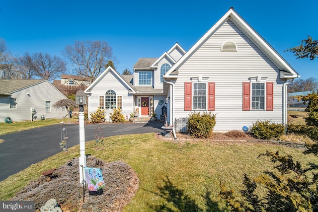 traditional-style home with driveway and a front yard