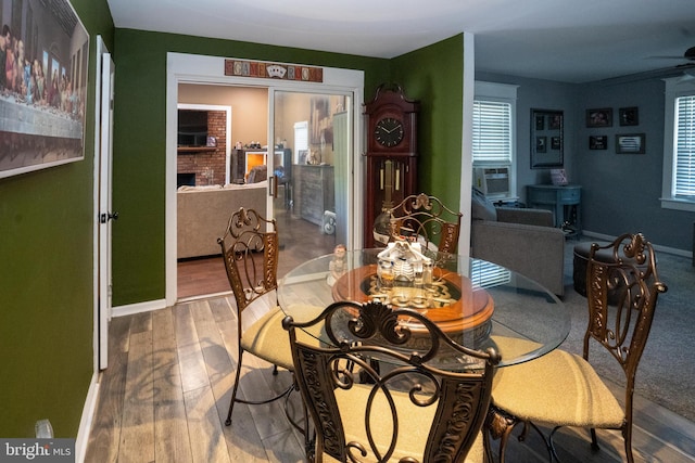 dining room with a healthy amount of sunlight, hardwood / wood-style flooring, and baseboards