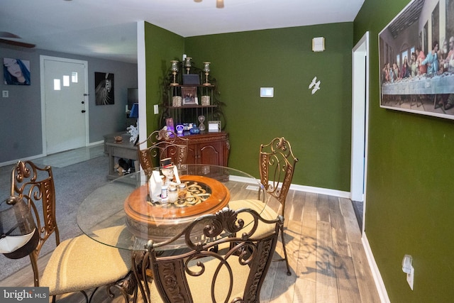 dining room featuring ceiling fan, baseboards, and wood finished floors