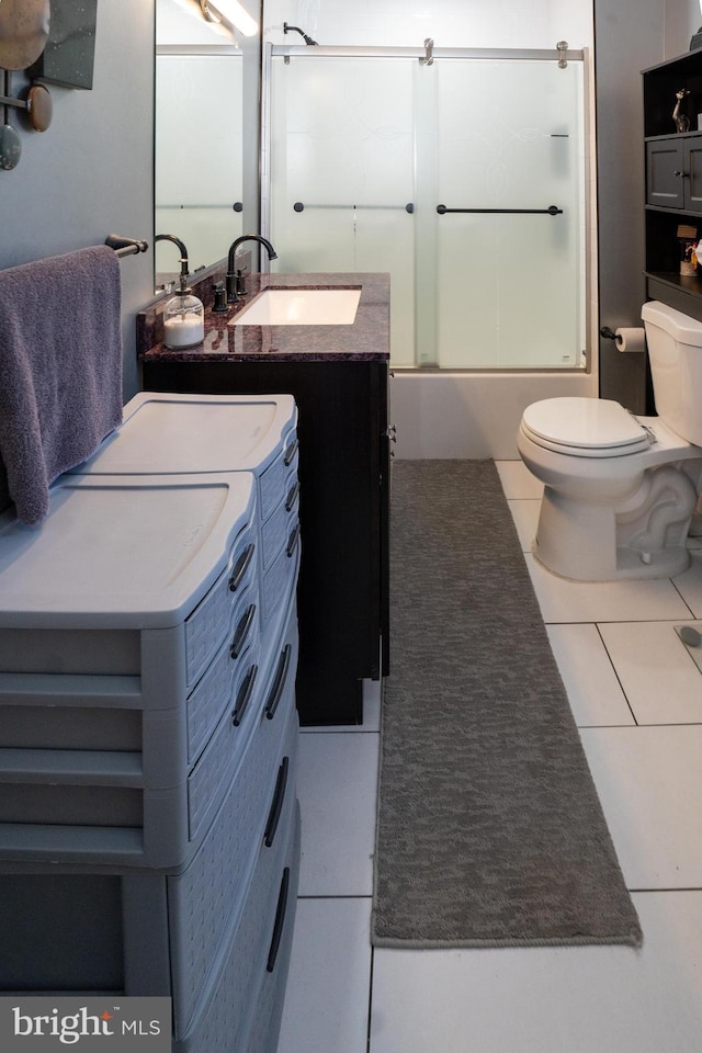 bathroom with toilet, shower / bath combination with glass door, tile patterned flooring, vanity, and washing machine and dryer