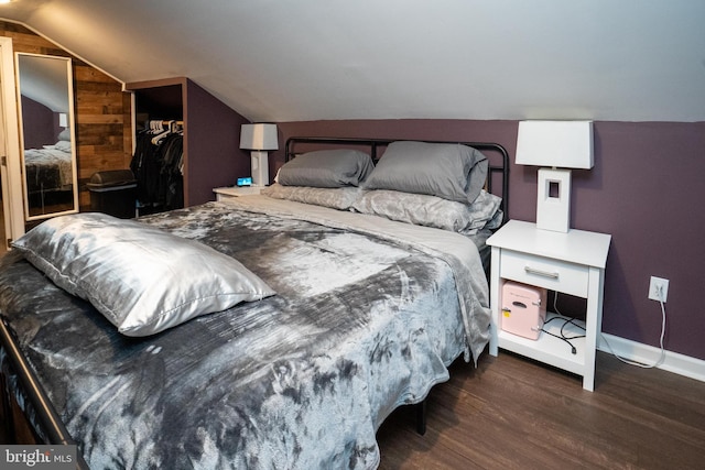 bedroom featuring lofted ceiling, a closet, baseboards, and wood finished floors