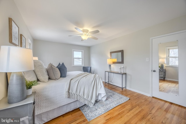 bedroom featuring light wood-style flooring, multiple windows, and baseboards