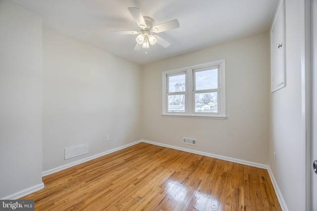 empty room featuring baseboards, visible vents, and light wood finished floors