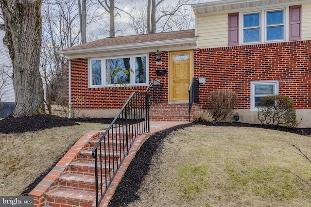 split level home featuring brick siding and a front lawn