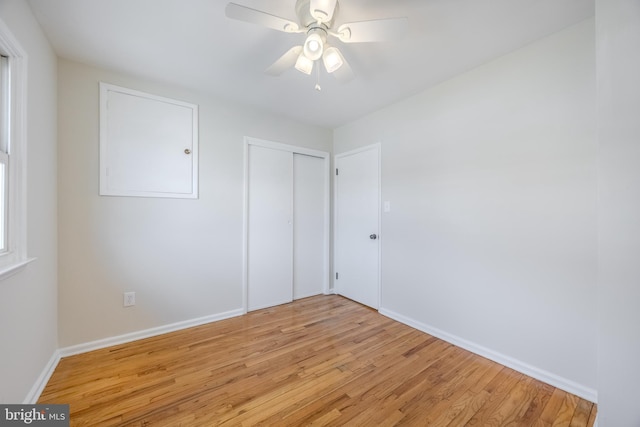 unfurnished bedroom with a ceiling fan, light wood-type flooring, a closet, and baseboards